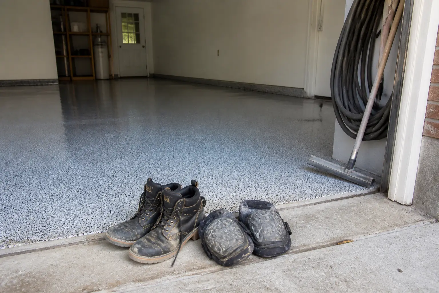 Work boots and tools at the edge of a coated floor