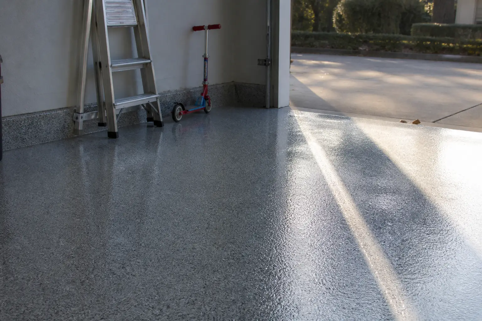 Polyaspartic flake garage floor with sunlight from the open door