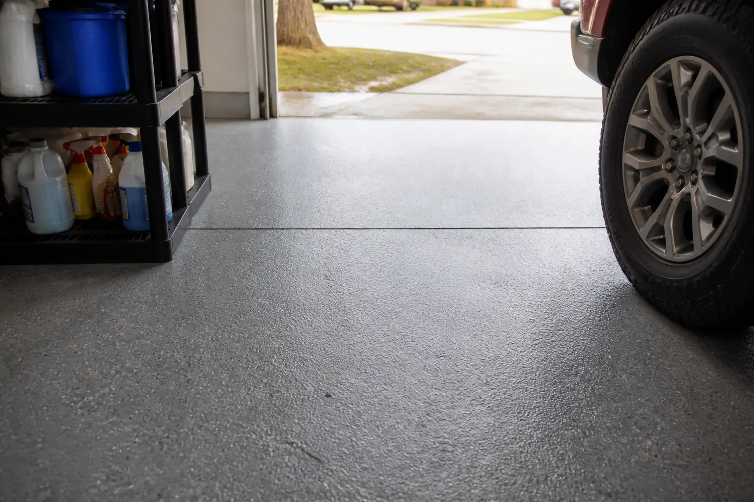 Grey polyurea garage floor with a control joint running across it